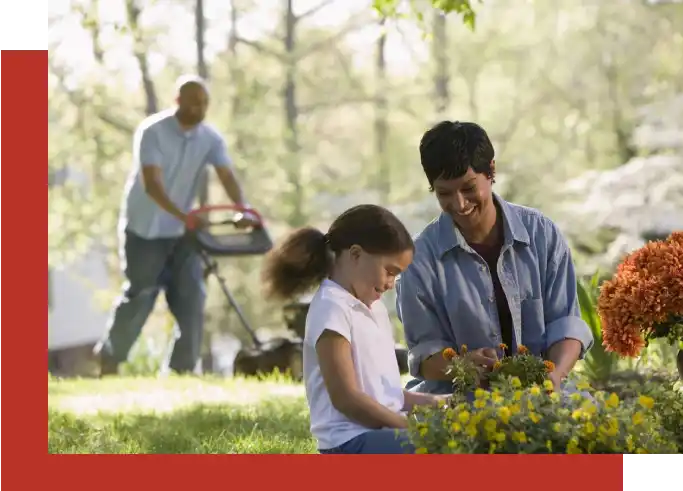 A man and woman with a girl in the grass.